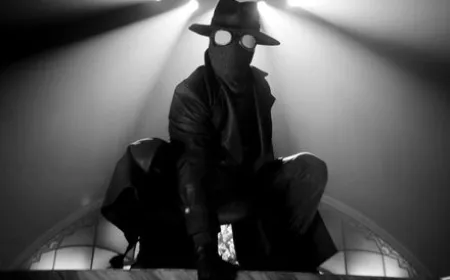 Ben Reilly stands in a trench coat and fedora against a shadowy cityscape in black and white.