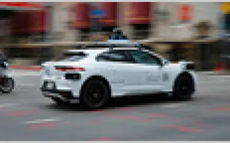 A robotaxi navigates a city street amid growing scrutiny over the rapid expansion of autonomous vehicle services.