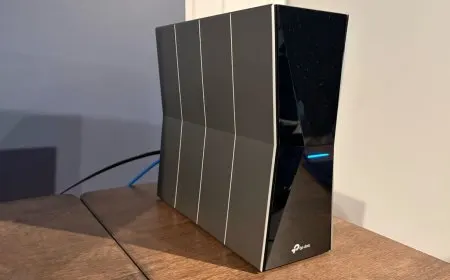 The TP-Link Archer BE770 router displays its tri-band antennas and four gigabit Ethernet ports on the front panel.