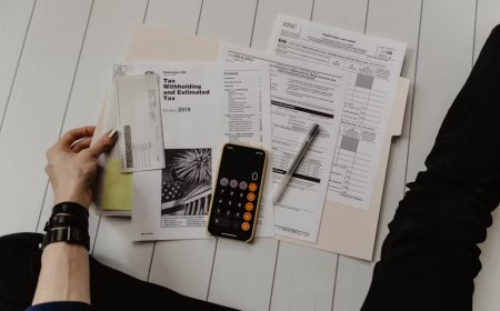 A desk displays organized financial documents and digital folders for tax record management.