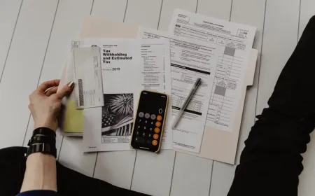 A desk displays organized financial documents and digital folders for tax record management.