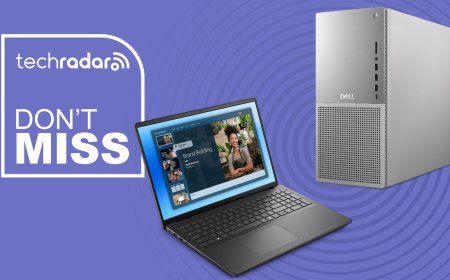 Dell business laptops and desktop towers are arranged on a promotional display table.