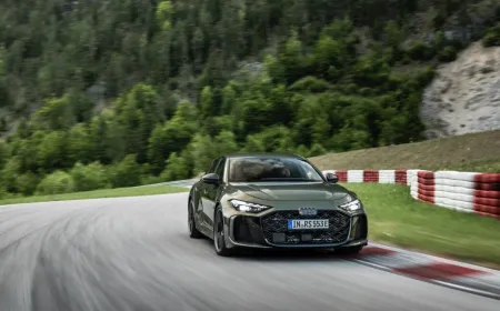 The 2027 Audi RS5 plug-in hybrid is shown from a front three-quarter angle on a paved road.