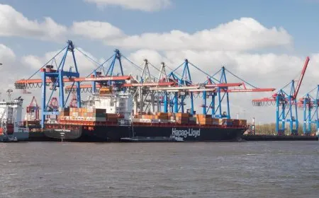 Cargo ships and shipping containers at a port illustrate halted freight operations to Cuba under new US sanctions.