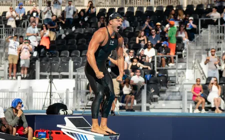 Cody Miller raises his arms in victory on a starting block at a makeshift Olympic pool in Las Vegas.
