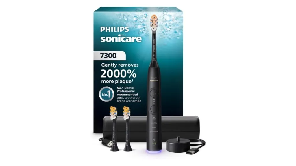 The Philips Sonicare 7300 Series electric toothbrush rests on its charging base with brush heads nearby.