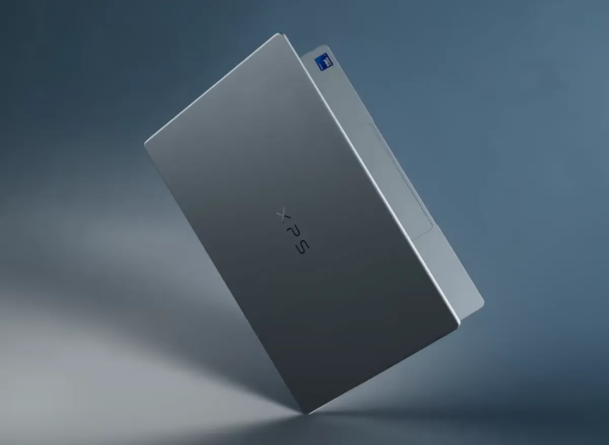 The silver Dell XPS 13 laptop is displayed open on a desk.