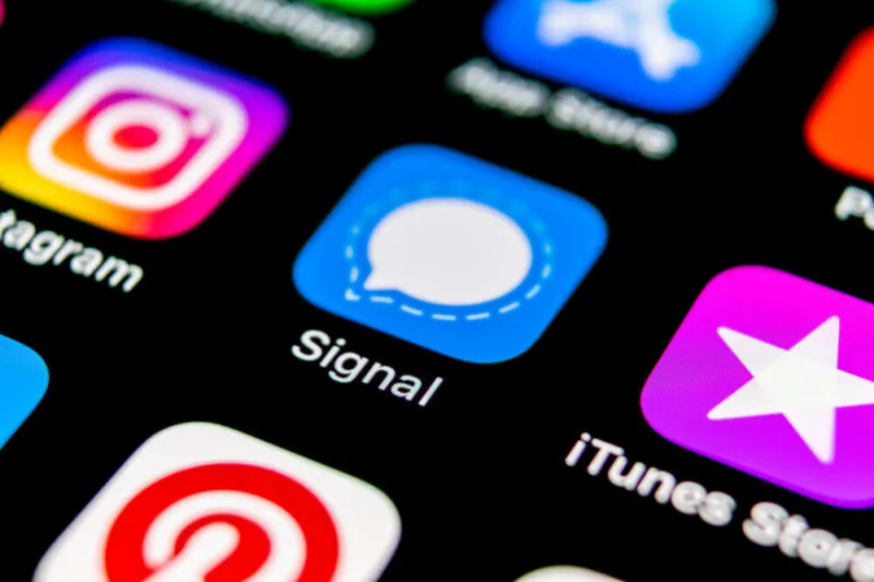 A smartphone screen displays encryption warnings alongside UK government surveillance graphics.