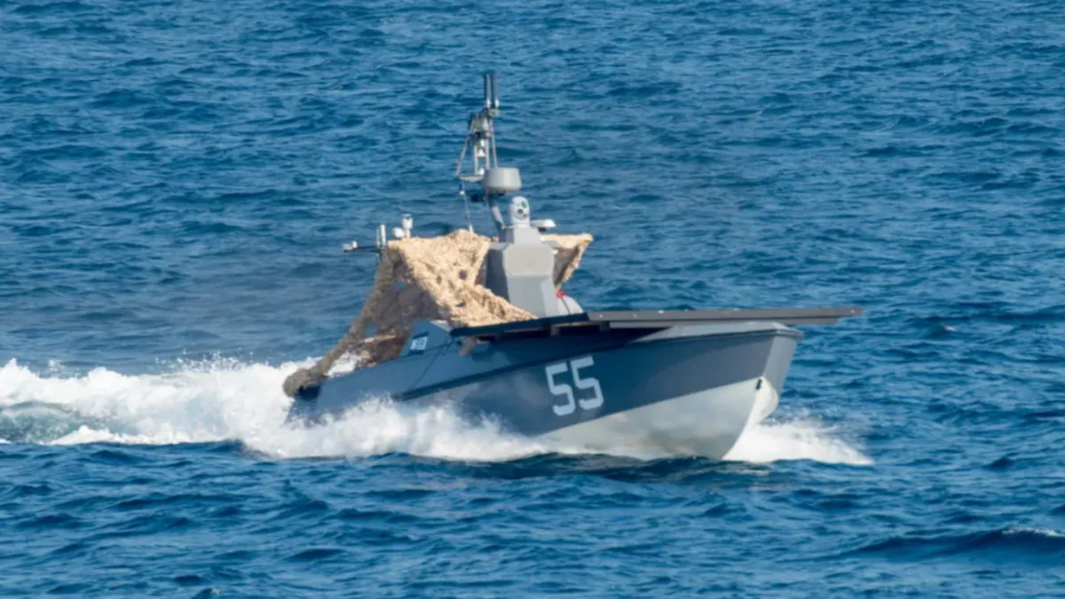 Uncrewed drone boat recovering a downed Apache helicopter crew near the Strait of Hormuz.