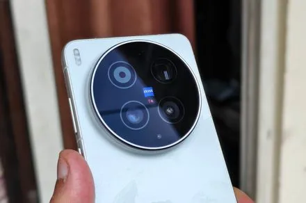 The Vivo X300 Ultra smartphone is shown with a modular grip and an attached teleconverter lens.