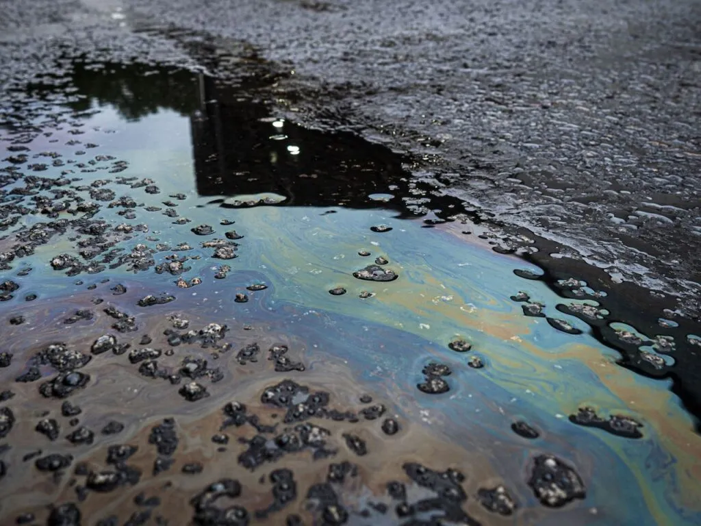 Crude oil residue spreading across Caribbean coastal waters, threatening marine habitats and fishing grounds.