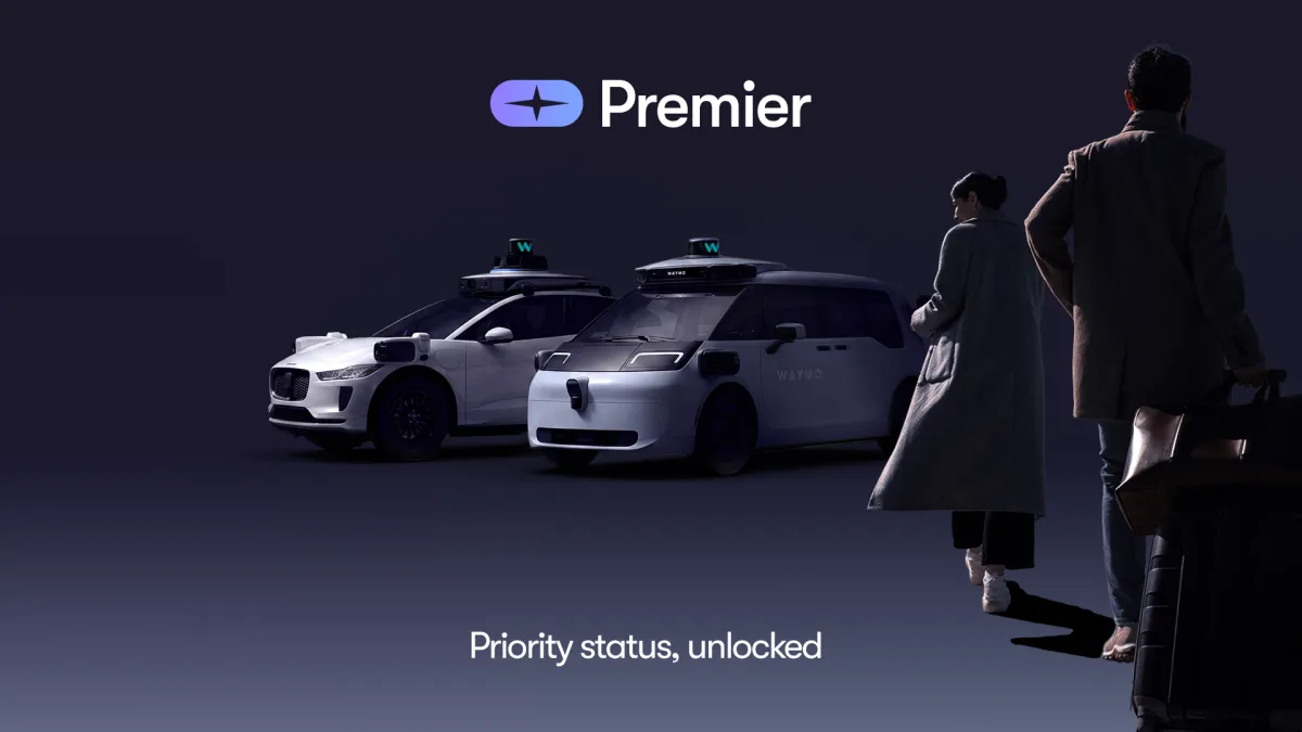 A Waymo autonomous vehicle is parked on a city street alongside promotional graphics for its new premium subscription tier.