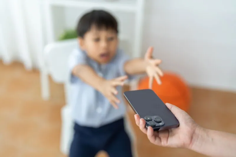 A child interacts with a digital tablet in a home setting.