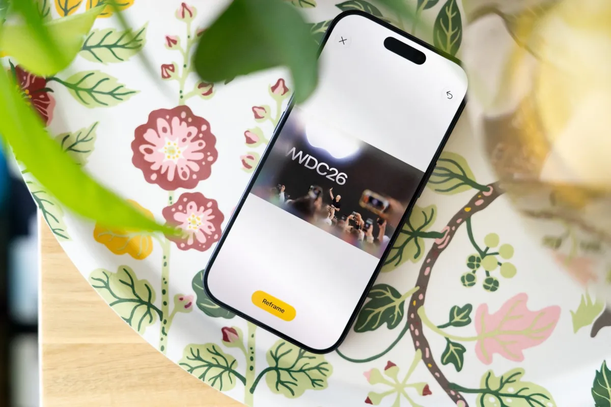A smartphone displays the iOS 27 interface for artificial intelligence photo editing and spatial reframing tools.