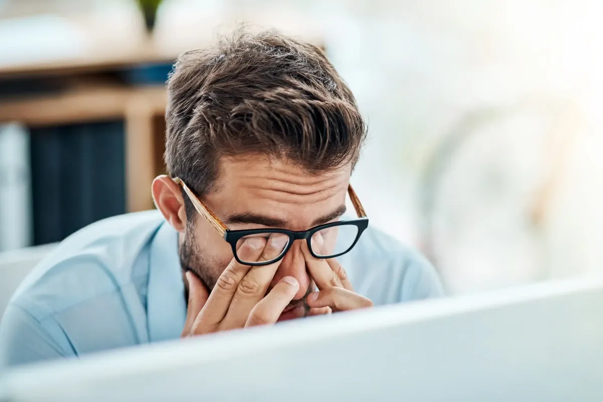 A desk worker maintains proper posture at an ergonomic workstation with a monitor.