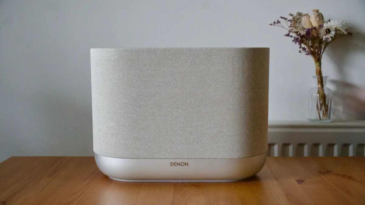 The Denon Home 400 wireless speaker features a cylindrical fabric enclosure with integrated touch controls.
