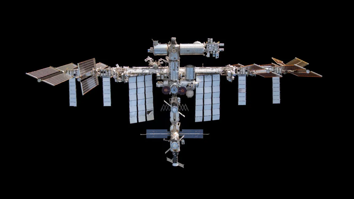 ISS crew members shelter in a SpaceX Crew Dragon lifeboat during an emergency protocol triggered by a Russian module leak.