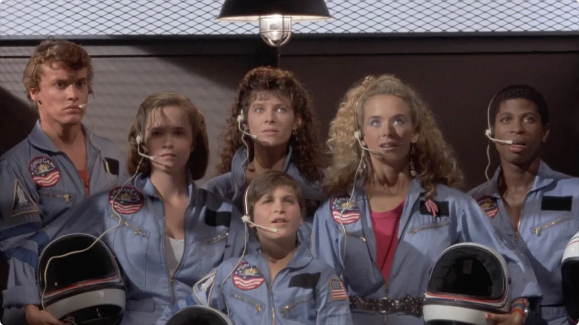 This promotional poster for the 1986 film SpaceCamp depicts young astronauts in a training facility.