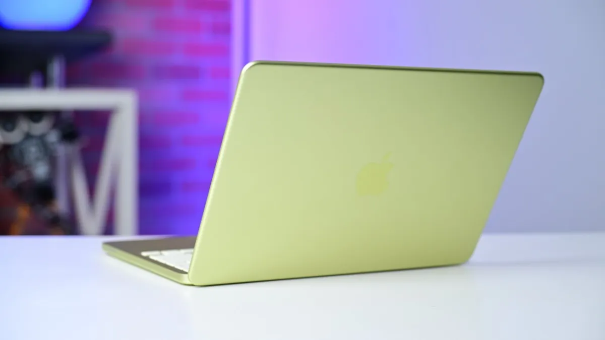 A silver MacBook Neo laptop sits open on a desk.