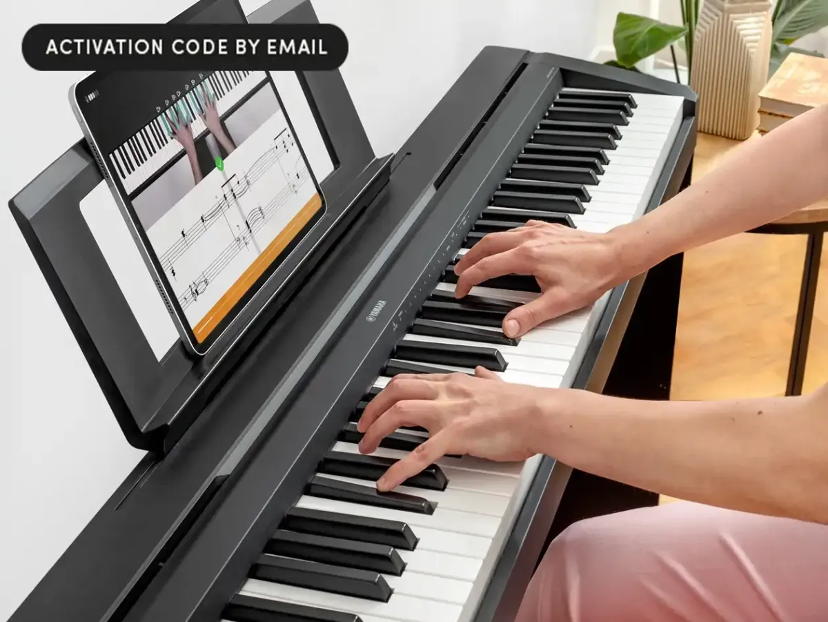 A digital piano keyboard sits beside a tablet displaying interactive lesson software