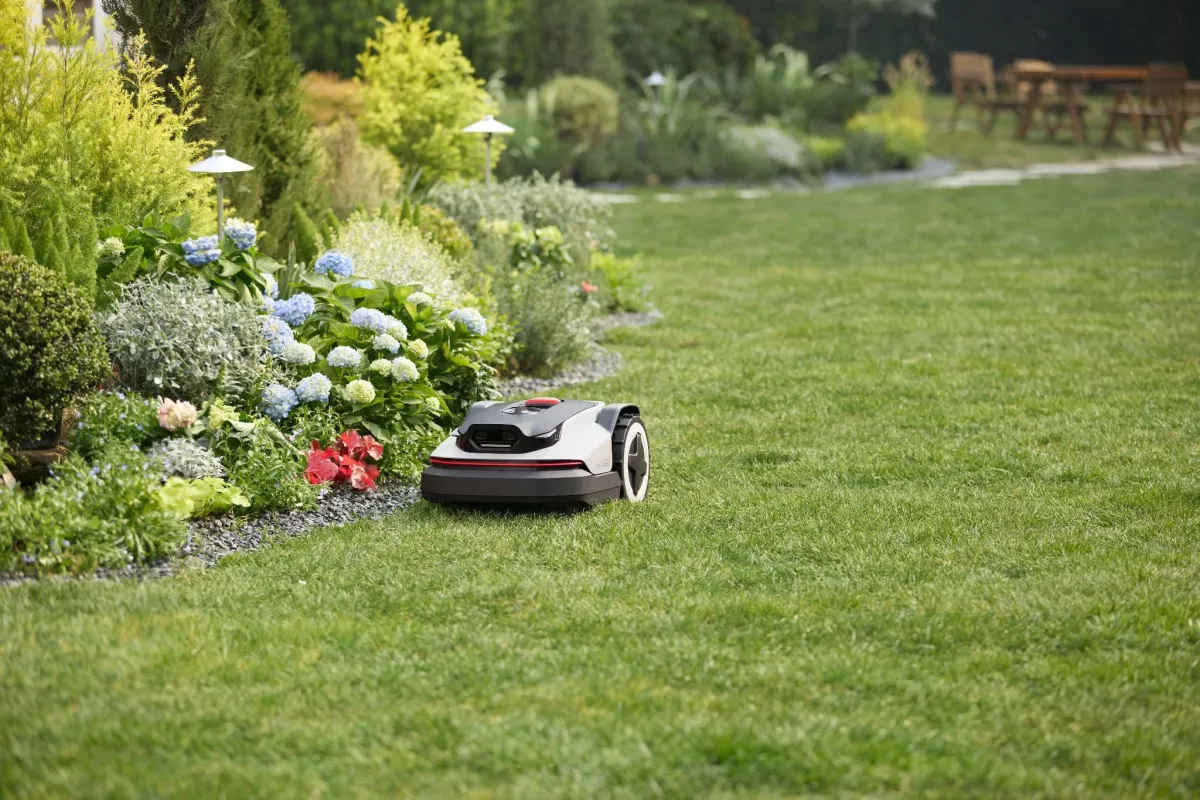 The Roborock RockNeo Q110H robot lawn mower operates on a residential lawn.