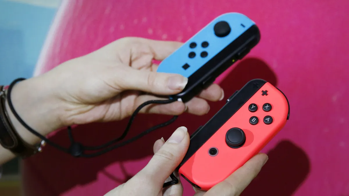 A Nintendo Switch Joy-Con controller is pictured alongside official documentation regarding the stick drift penalty.