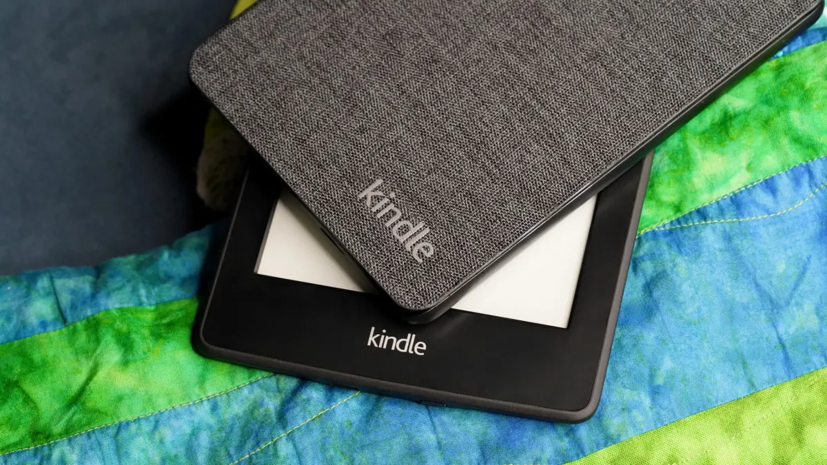 A Kindle e-reader being modified by a user to extend its lifespan and bypass software restrictions.