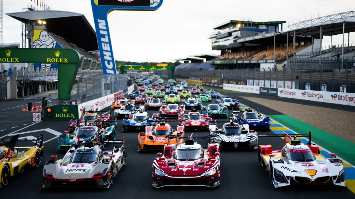 Spectators watch racing cars compete during the day and night at the 24 Hours of Le Mans.