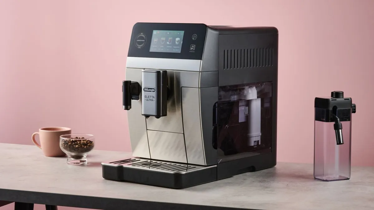 A De'Longhi bean-to-cup coffee machine brews hot and cold beverages on a kitchen counter.