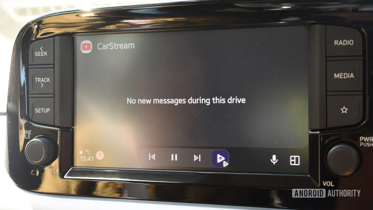 A smartphone displays the Android Auto interface while connected to a vehicle.