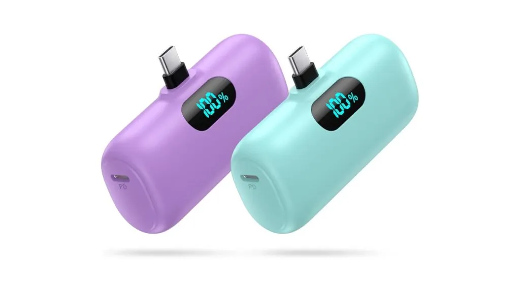 Compact USB-C power bank beside a smartphone and charging cable, demonstrating its small portable size.