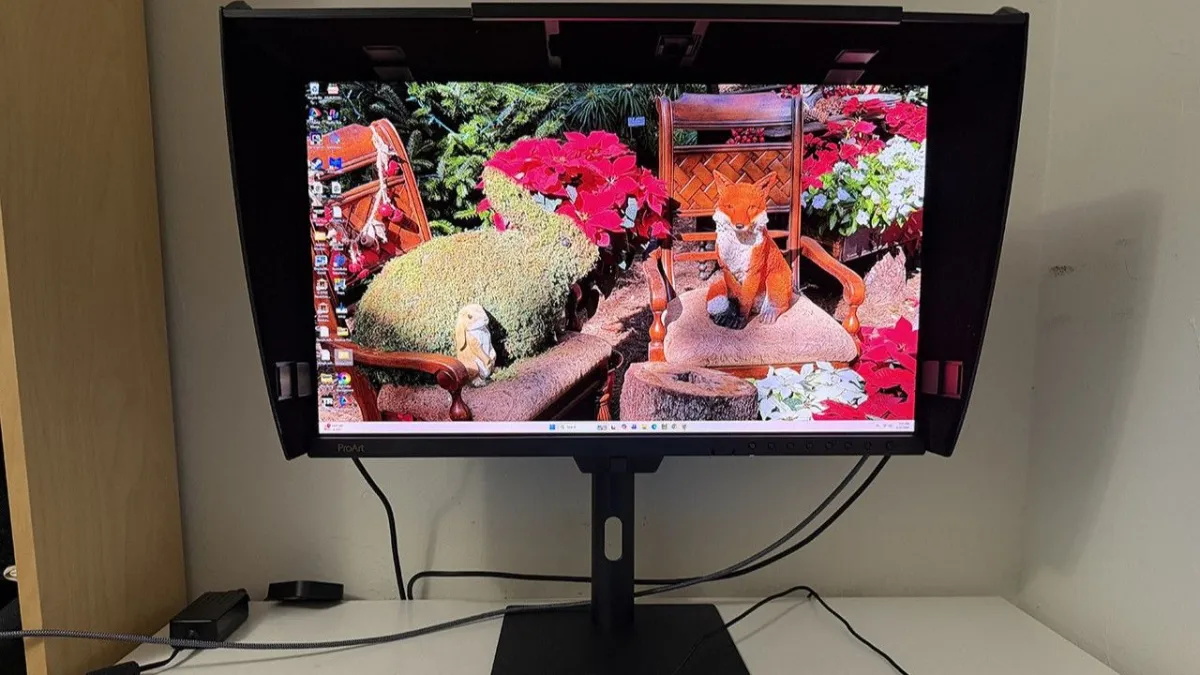 The Asus ProArt PA27USD OLED monitor displays a test pattern with visible rear ports.