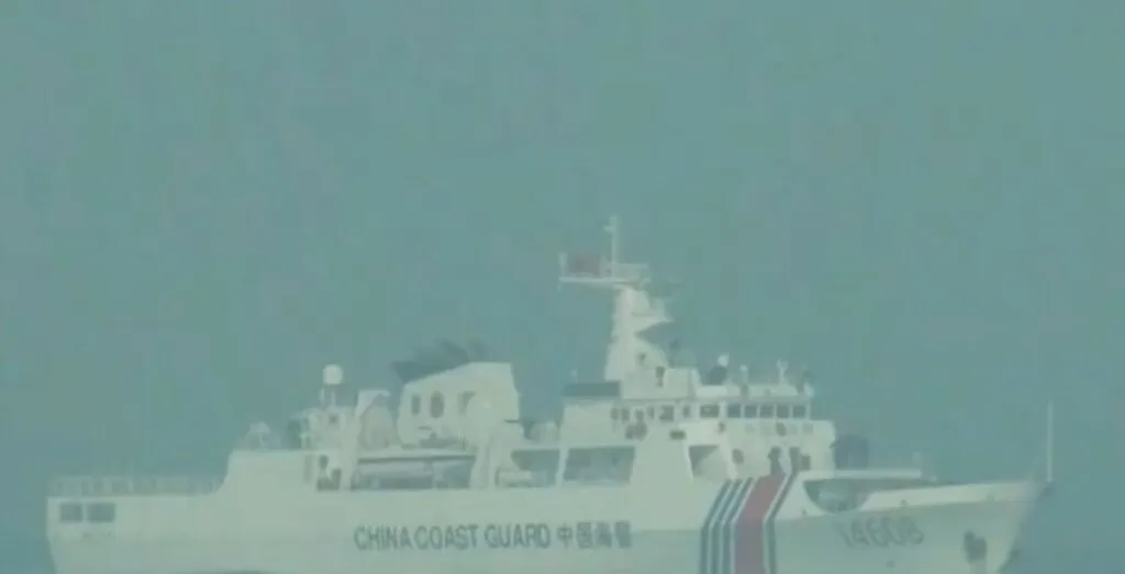 Chinese coast guard vessels navigate near Taiping Island during heightened territorial disputes in the South China Sea.