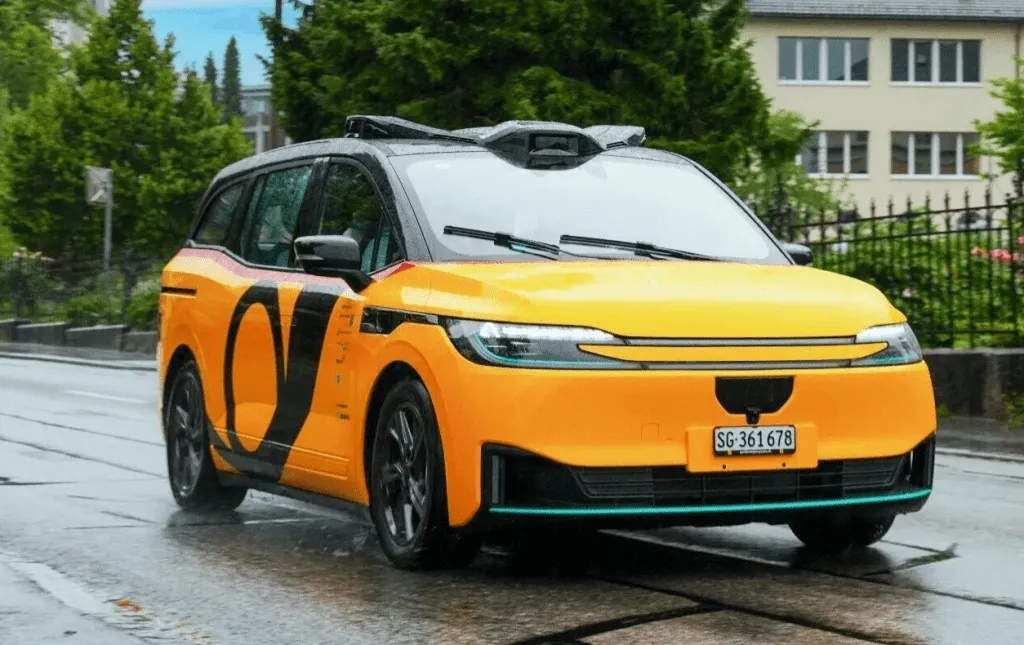Baidu Apollo Go autonomous vehicle undergoing road testing alongside PostBus in Switzerland