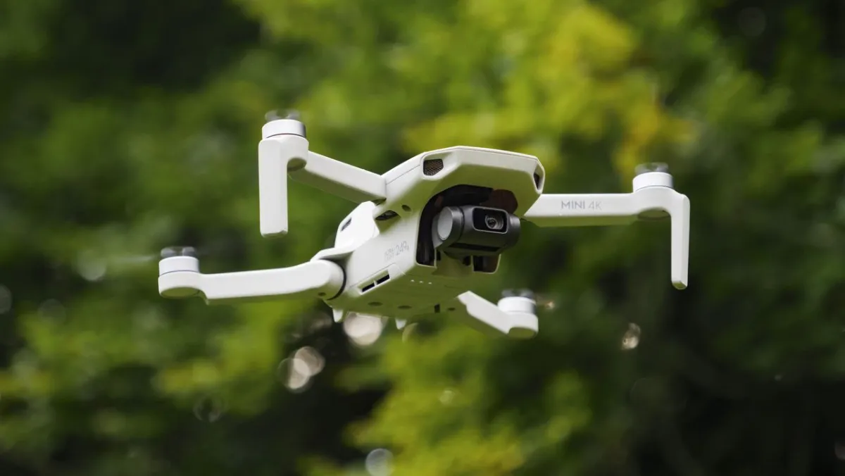 A drone sits near a World Cup stadium with a temporary no-fly zone warning sign.