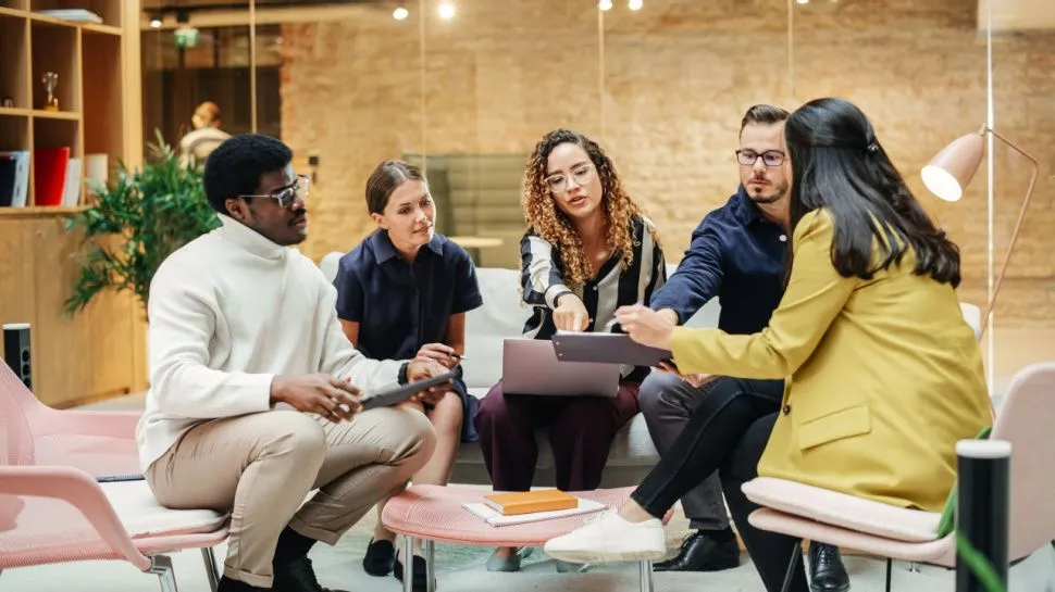 Remote employee isolated on a laptop screen during a hybrid meeting plagued by audio and video delays