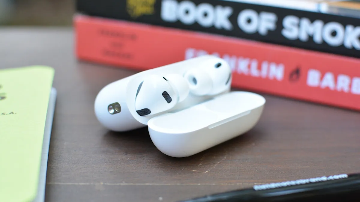 AirPods rest beside an iPhone screen displaying the Camera Remote settings menu.