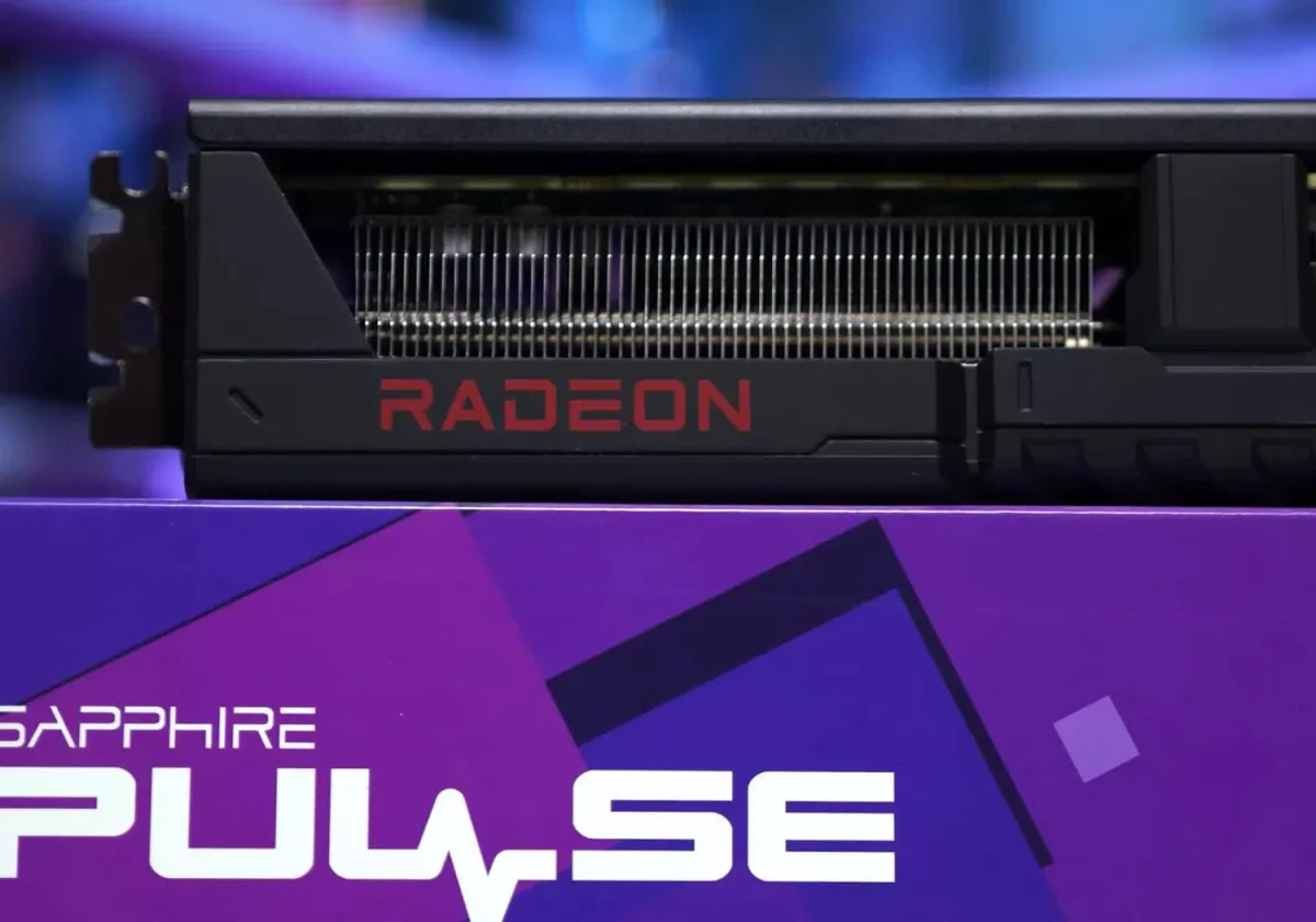 The AMD Radeon RX 9070 GRE graphics card is displayed at an angle with its silver and black cooling shroud visible.