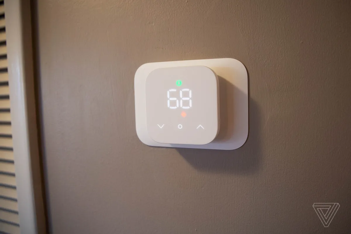 Amazon Smart Thermostat mounted on a wall with a digital display showing temperature settings.