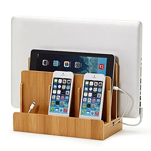 A neatly arranged desk displays an iPhone on a charging stand alongside cables and accessories for ergonomic access.