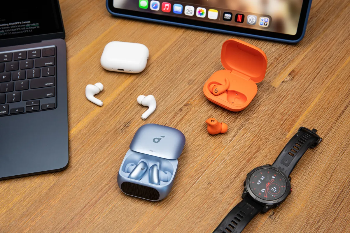The image displays Soundcore Liberty 5 Pro, AirPods Pro 3, and Beats Powerbeats Fit wireless earbuds arranged side by side.