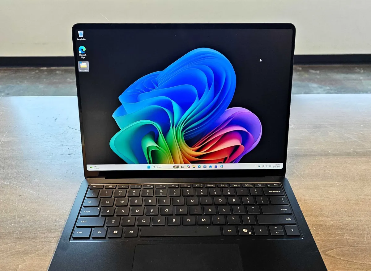 The silver Surface Laptop 8 for Business rests open on a desk to display its keyboard and screen.