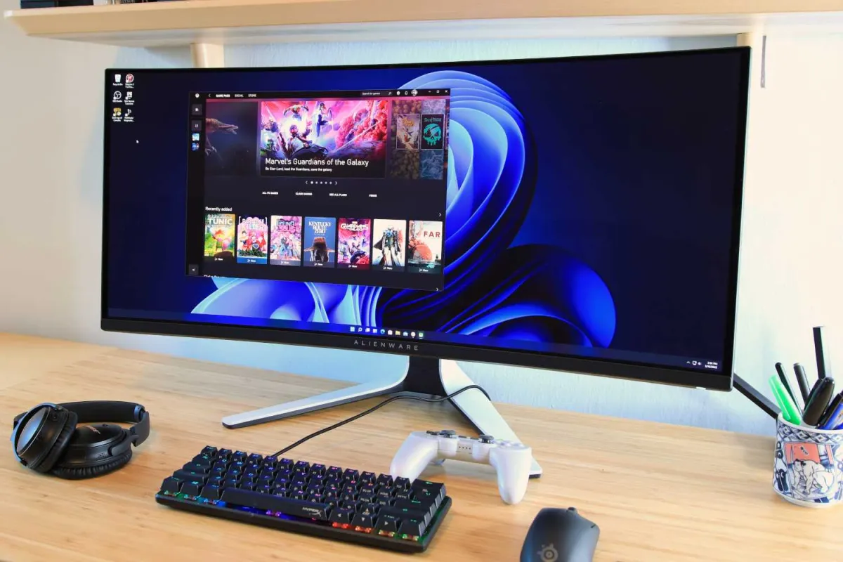 A modern monitor displays productivity and gaming interfaces on a clean desk setup.