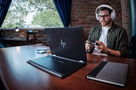 A convertible laptop displays media content and productivity applications simultaneously.