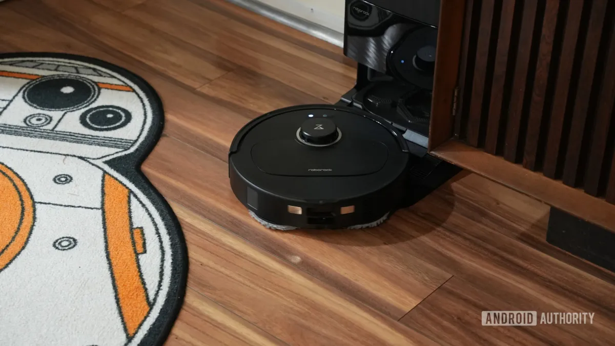 Roborock Qrevo S5V robot vacuum and mop beside its docking station with dual spinning mops and water refilling system