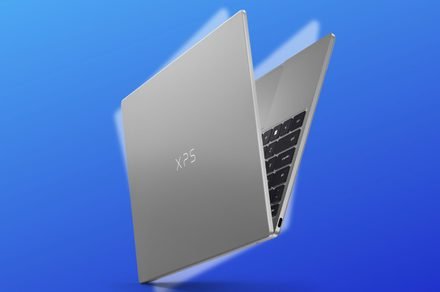 The Dell XPS 13 laptop is displayed open to show its slim chassis and backlit keyboard.