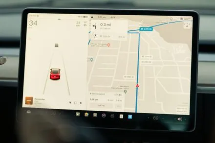 Miniature figurines positioned near a Tesla interior camera to bypass driver monitoring systems.