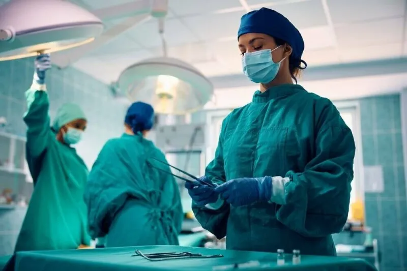An NHS hospital building displays digital network graphics for patient data management.