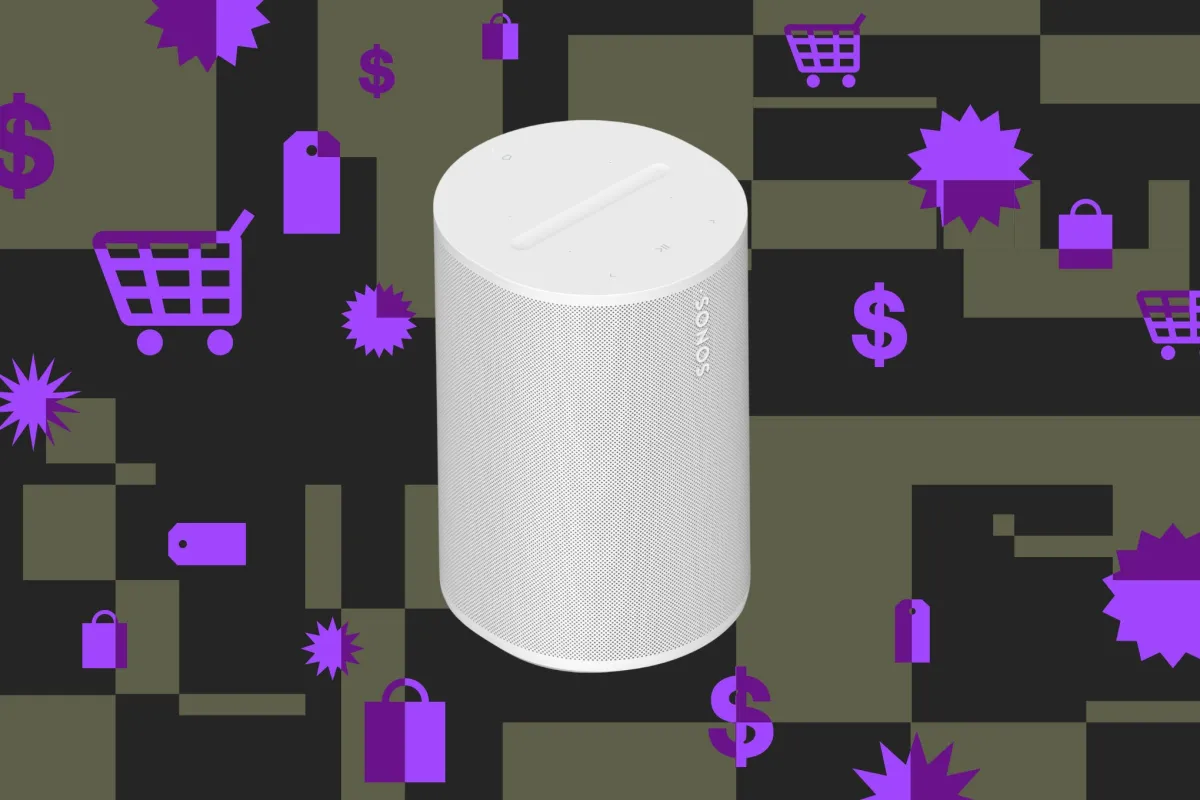 The Sonos Era 100 compact smart speaker sits on a wooden surface.