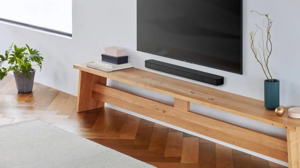 A compact soundbar features visible bass reflex ports to enhance low-frequency audio response.